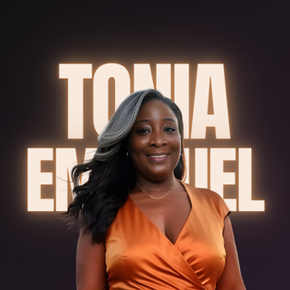 Portrait of Tonia Emanuel, a Black woman with long hair and a silver streak, wearing an orange satin dress, smiling in front of large illuminated letters spelling her name.